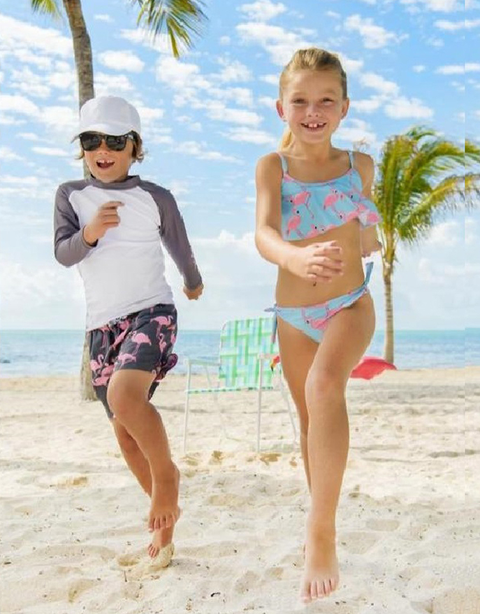 A couple of children in swimwear running towards the camera