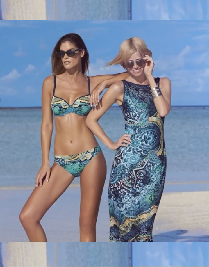 A woman in a bikini standing next to a woman in a beach dress